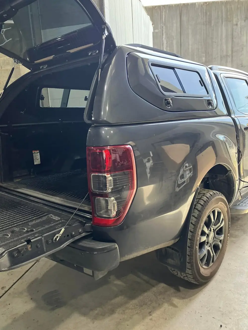 The rear tray and canopy of a grey Ford Ranger ute with the tailgate open