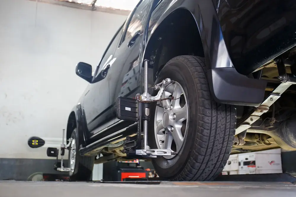 A wheel alignment sensor clamped to a vehicle's wheel while raised on a hoist